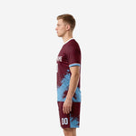 Custom maroon and sky blue soccer kit right-side view with sublimated splash design across jersey hem and shorts