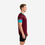 Custom maroon soccer training jersey showing teal gradient sleeve fade from cuff to shoulder, side view on male model