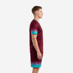Custom maroon and teal gradient soccer kit side view showing sleeve cuff and shorts hem gradient
