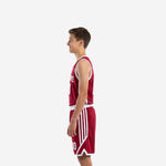 Side view of maroon and white youth basketball uniform set showing white armhole binding and angled white stripe panels on the shorts legs