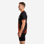 Custom mens soccer practice jersey right side profile showing orange fire design and orange sleeve cuff trim