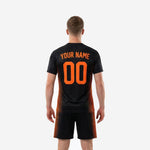 Close detail of sublimated athletic orange stripe panels on jet black men's soccer team uniform jersey, showing color depth and fiber-bonded print quality
