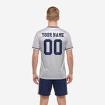 Detail view of custom men's soccer team uniform showing crew neck Navy Blue trim and cuff stripe on Silver-Grey jersey