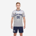 Custom men's soccer team uniforms in Silver-Grey iridescent jersey and Navy Blue shorts, front view with team name and number