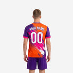 Detail view of custom men's soccer jersey in orange and purple full-dye sublimation splash print with crew neck hot pink trim