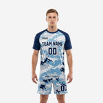 Custom men's soccer uniforms in Navy Blue and Ice Blue digital camo pattern with raglan sleeves, front view showing team name and number