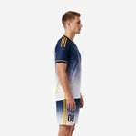 Custom men's soccer uniform navy and white gradient left side view showing gold shoulder stripes and matching gradient shorts with side panel stripe