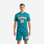 Custom men's soccer uniforms in teal camo with blaze orange trim, front view of full 2-piece matchday kit