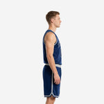 Side view of custom navy basketball uniform set showing white and silver armhole binding on sleeveless jersey and silver-stripe waistband on matching shorts
