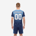 Close-up detail of custom Navy Blue and Sky Blue men's soccer jersey showing dot-burst gradient sublimation print and V-neck white collar trim