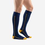 Custom navy blue soccer socks with gold contrast heel and side stripe, left side view on adult male model