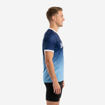 Custom blue and white training jersey side view showing gradient fade from navy shoulder to sky blue hem on male model