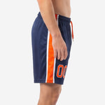 Custom navy blue soccer shorts showing orange and white contrast side stripe, side view on male model