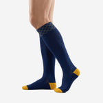 Over the calf custom navy blue soccer socks with Athletic Gold accent blocks at heel and toe, angled side view