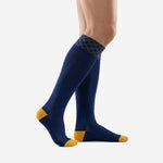Custom navy blue soccer socks showing Athletic Gold heel and toe contrast panels, side profile view on adult male model