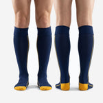 Reinforced heel block in athletic gold on custom navy blue knee-high soccer socks, rear angle detail