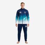 Custom navy blue soccer tracksuit with teal gradient and constellation print, front view on male model