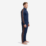 Left side view of custom navy and gold soccer tracksuit displaying old gold chevron stripe running from shoulder to ankle on male model