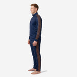 Right side view of custom navy blue soccer tracksuit with old gold geometric chevron stripe panels and tapered pant cut on male model