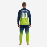 Close up of custom navy and green soccer tracksuit jacket showing team logo placement on chest and sublimated gradient colorway