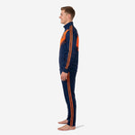 Men's custom navy and orange soccer tracksuit side profile displaying orange brushstroke chest panel and matching tapered track pants