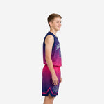 Front view of custom navy and pink boys basketball uniforms showing V-neck jersey and matching gradient shorts on youth model