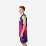 Side view of navy to hot pink gradient youth boys basketball uniform set showing bound armhole and shorts side split detail