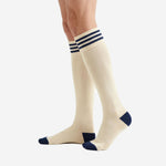 Custom navy and white soccer socks right side view showing cream ivory calf panel with elastic triple-stripe navy top band on male player