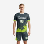 Custom neon green soccer uniforms in charcoal with splash print, front view on male model, jersey and matching shorts