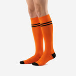 Custom orange and black soccer socks angled view showing full leg coverage and black heel reinforcement