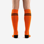 Custom orange and black soccer socks close-up of ribbed cuff and double black contrast stripe detail