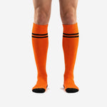 Custom orange and black soccer socks front view showing double black stripe bands and ribbed cuff
