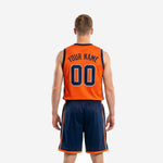 Opposite side view of orange basketball uniform with navy side panels on jersey and orange double-stripe detail running the full length of navy shorts