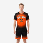 Custom orange soccer uniform with black gradient print, crew neck white trim, and matching shorts - front view on male model