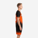 Custom orange and black gradient soccer uniform side view showing full sleeve and shorts gradient on adult male model