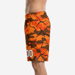 Side view of custom orange camo basketball shorts showing mid-thigh length, side split at hem, and full-dye sublimated camo-crack pattern