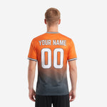 Full body lifestyle shot of custom orange soccer jersey with charcoal gradient hem and contrast stripe sleeve cuffs on adult male