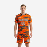 Custom orange digital camo soccer uniform front view showing team name and number on jersey and matching shorts