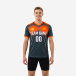 Custom orange soccer training jersey in graphite and orange gradient with team name and number on chest, front view on male model