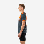Orange and graphite custom soccer training jersey right side view showing back name print and orange collar trim on male model