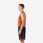 Side view of custom orange and navy basketball uniform showing orange jersey side panel stripe and navy shorts outer-leg orange stripe construction