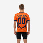 Back view of custom orange soccer training jersey with navy geometric graphics, back number and player name print zones