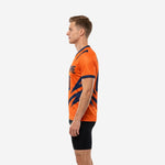 Orange soccer training jersey with bold navy diagonal strike pattern across side panels, right side view on adult male model