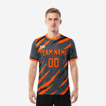 Custom orange soccer jersey in Charcoal and Athletic Orange slash-stripe print, front view on male model showing team name and number
