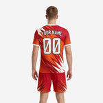 Close detail of custom orange soccer jersey with red spike graphics and white V-neck contrast trim