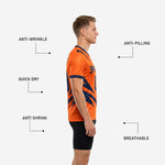 Close-up of navy blue geometric strike graphics on custom orange soccer training jersey, full-dye sublimation detail