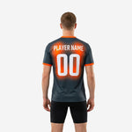 Detail view of custom orange soccer training jersey showing team name and player number printed in white via full-dye sublimation