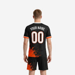 Back view of custom orange soccer uniform in Jet Black with Athletic Orange splash graphic and white player name and number