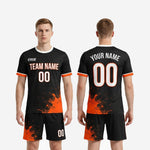 Full flat lay of custom orange soccer uniform set including Jet Black jersey and matching shorts