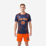 Custom orange soccer uniform with navy blue sublimated jersey featuring lightning graphic and orange shorts, front view on male model